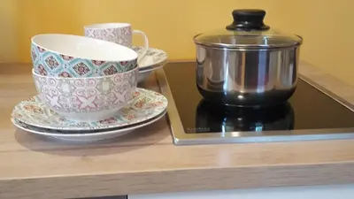 a cup and saucers on a counter with a coffee maker at Apartments Life & Energy in Čatež ob Savi