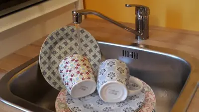 a sink with two cups sitting in it at Apartments Life & Energy in Čatež ob Savi