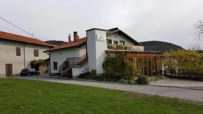 a large white house with a car parked in front of it at Janezinovi House in Ratečevo Brdo