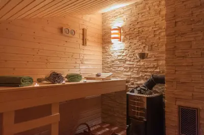 a room with a fireplace and a wooden wall at Janezinovi House in Ratečevo Brdo