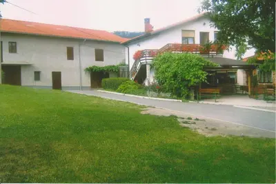 a house with a green lawn in front of it at Janezinovi House in Ratečevo Brdo