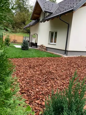 a house with a mulicked yard in front of a house at Remarkable home Bohinj Lake in Bohinj