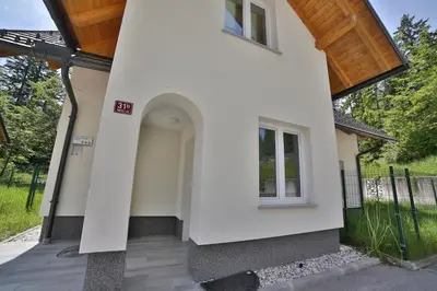 a side view of a white house with a porch at Remarkable home Bohinj Lake in Bohinj