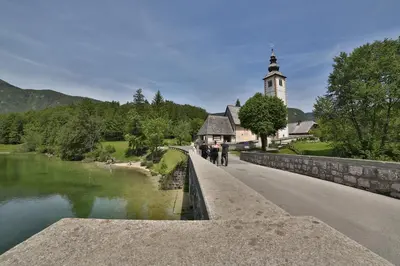 a group of people walking on a bridge over a river at Remarkable home Bohinj Lake in Bohinj