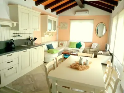 a kitchen and living room with a table and a couch at Holiday Home Slavi in Vipava