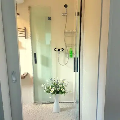 a bathroom with a vase of flowers in a shower at Holiday Home Slavi in Vipava