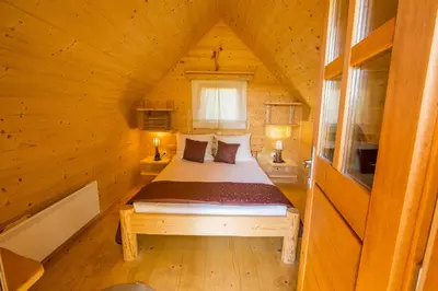 a bedroom in a log cabin with a bed in it at Glamping Organic Farm Slibar in Tržič