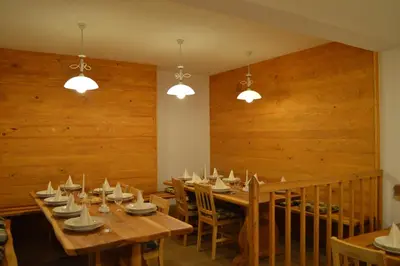 a dining room with wooden walls and wooden tables and chairs at Glamping Organic Farm Slibar in Tržič