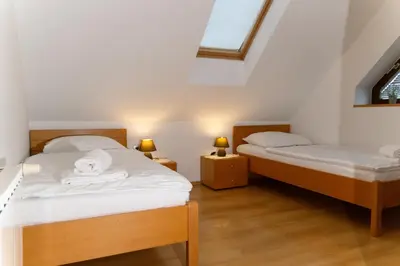 two twin beds in a room with two lamps at Martinova izba - Rooms & Apartments in Laško