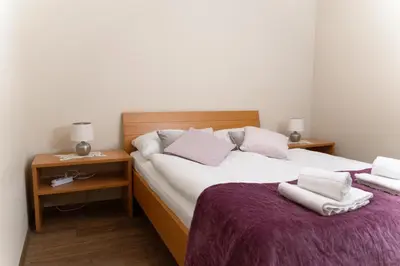 a bedroom with a large bed with two pillows at Martinova izba - Rooms & Apartments in Laško