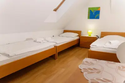 a room with two beds and a night stand at Martinova izba - Rooms & Apartments in Laško