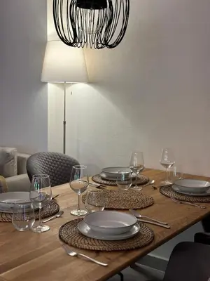 a wooden table with plates and glasses and a chandelier at Martinova izba - Rooms & Apartments in Laško