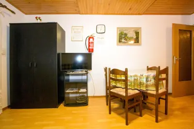 a dining room with a table and a black cabinet at Zeleni apartma Zreče in Zreče