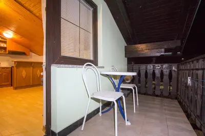 a table and chairs in a room with a window at Zeleni apartma Zreče in Zreče