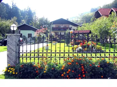 a black wrought iron fence with flowers in a yard at Zeleni apartma Zreče in Zreče