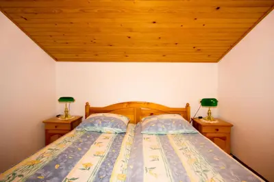 a bedroom with a bed with two lamps on night stands at Zeleni apartma Zreče in Zreče