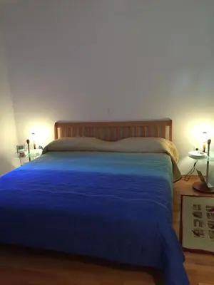 a bedroom with a blue bed with two tables at Apartment on Zdraviliski trg 7 in Rogaška Slatina