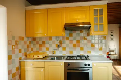 a kitchen with yellow cabinets and a sink at Eko Homestead Luka - Escape Room, Archery, BBQ, Rafting and more - in Vrh pri Fari