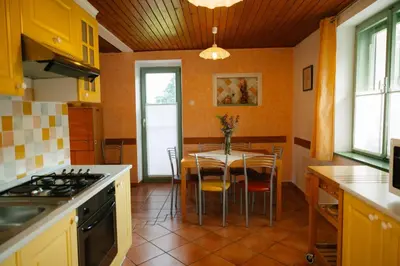 a kitchen with a table and a dining room at Eko Homestead Luka - Escape Room, Archery, BBQ, Rafting and more - in Vrh pri Fari