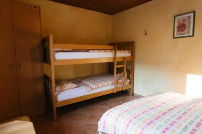 two bunk beds in a room with a bed at Eko Homestead Luka - Escape Room, Archery, BBQ, Rafting and more - in Vrh pri Fari