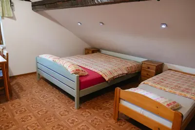a bedroom with two beds in a attic at Eko Homestead Luka - Escape Room, Archery, BBQ, Rafting and more - in Vrh pri Fari