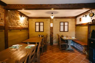 a dining room with wooden tables and chairs at Eko Homestead Luka - Escape Room, Archery, BBQ, Rafting and more - in Vrh pri Fari