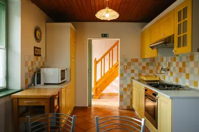 a kitchen with yellow cabinets and a table with chairs at Eko Homestead Luka - Escape Room, Archery, BBQ, Rafting and more - in Vrh pri Fari
