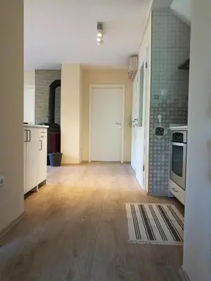 an empty room with a kitchen with wooden floors at Apartment Belaj in Celje