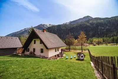 a small house in a field with a fence at Holiday Home Vila Kopriva in Gozd Martuljek