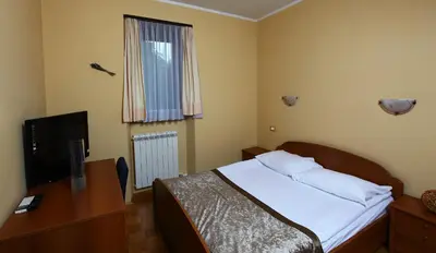 a bedroom with a bed and a desk and a television at Bed and Breakfast Malovec in Divača
