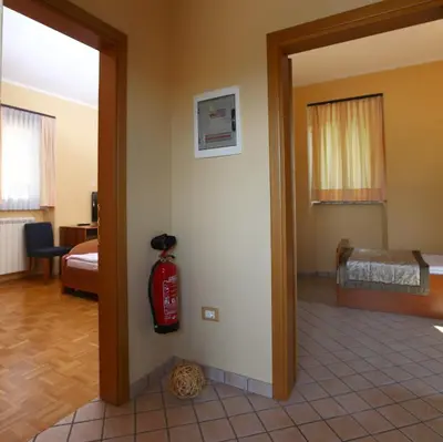 a room with a fire extinguisher next to a bedroom at Bed and Breakfast Malovec in Divača
