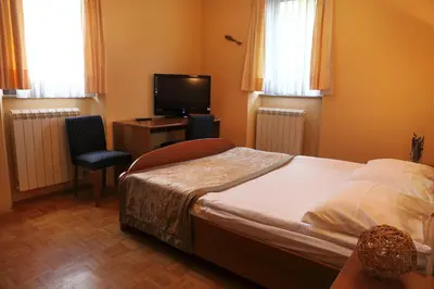 a bedroom with a bed and a desk and a television at Bed and Breakfast Malovec in Divača