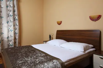 a bedroom with a bed with white sheets and a wooden headboard at Bed and Breakfast Malovec in Divača