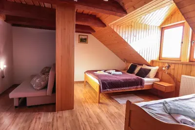 a bedroom with a bed and a chair in a attic at EkoTurizem Viženčar in Cerklje na Gorenjskem
