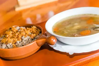 a bowl of soup next to a bowl of food at EkoTurizem Viženčar in Cerklje na Gorenjskem