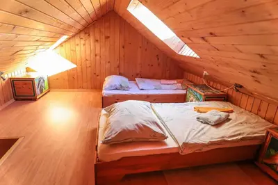 a bedroom with two beds in a wooden cabin at EkoTurizem Viženčar in Cerklje na Gorenjskem