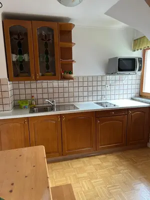 a kitchen with wooden cabinets and a sink at Tourist farm Gradišnik in Solčava
