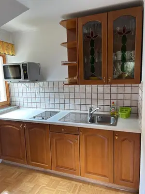 a kitchen with wooden cabinets and a sink at Tourist farm Gradišnik in Solčava
