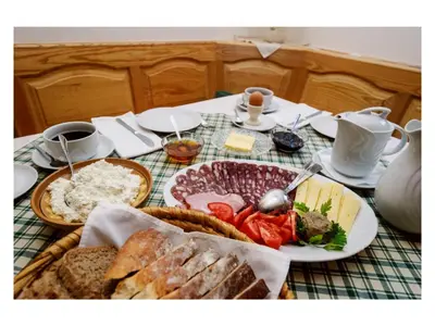 a table with a plate of food with bread and meats at Turistična kmetija Stoglej in Luče