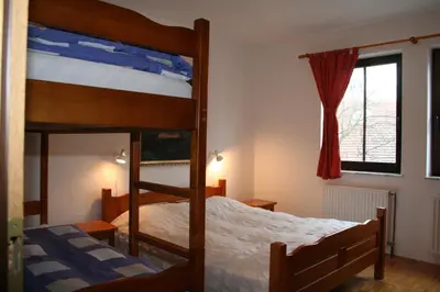 a bedroom with two bunk beds and a window at Apartments Lovšin in Mozirje