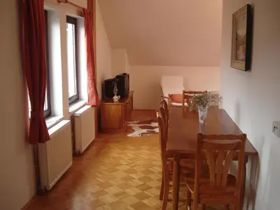 a dining room with a wooden table and chairs at Apartments Lovšin in Mozirje