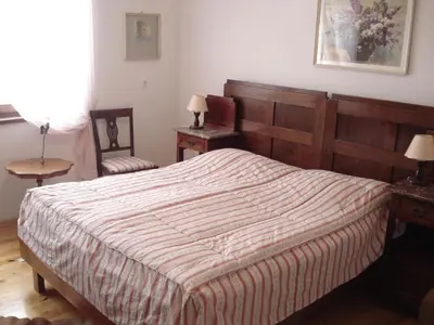 a bedroom with a large bed with a wooden headboard at Apartments Lovšin in Mozirje