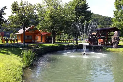 a pond with a fountain in the middle of a park at Apartments Lovšin in Mozirje