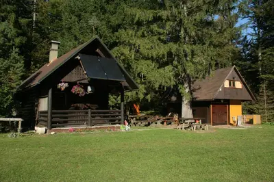 a log cabin with people sitting outside of it at Fikfak cottage in Bled