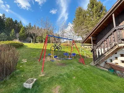 a playground in a yard next to a house at Apartment Panorama in Zreče