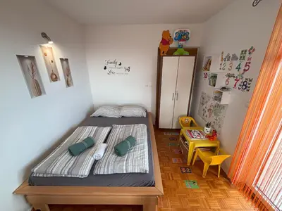 a small bedroom with a bed and a table at Apartment Panorama in Zreče