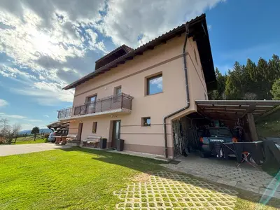 a house with a car parked in front of it at Apartment Panorama in Zreče