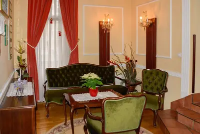a living room with two chairs and a table and a couch at Penzion Gostilna Keber in Domžale