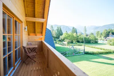 a balcony of a house with a view of a yard at Brunarica Murka in Bohinj