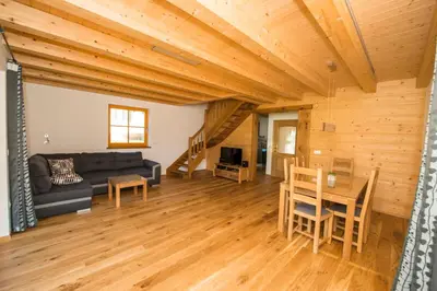 a living room with a couch and a table at Brunarica Murka in Bohinj